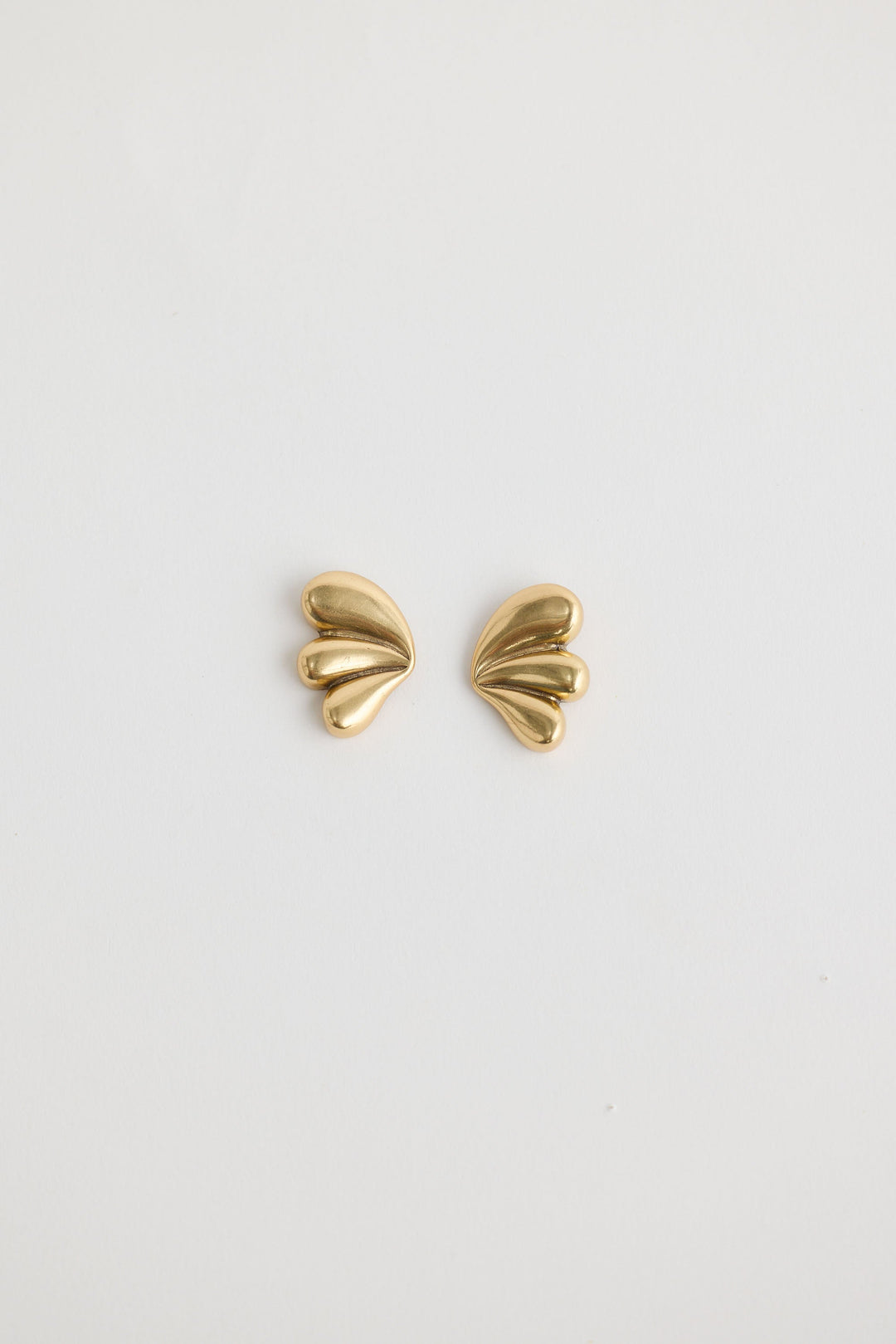 Close-up of gold taylor earrings earrings on white background.