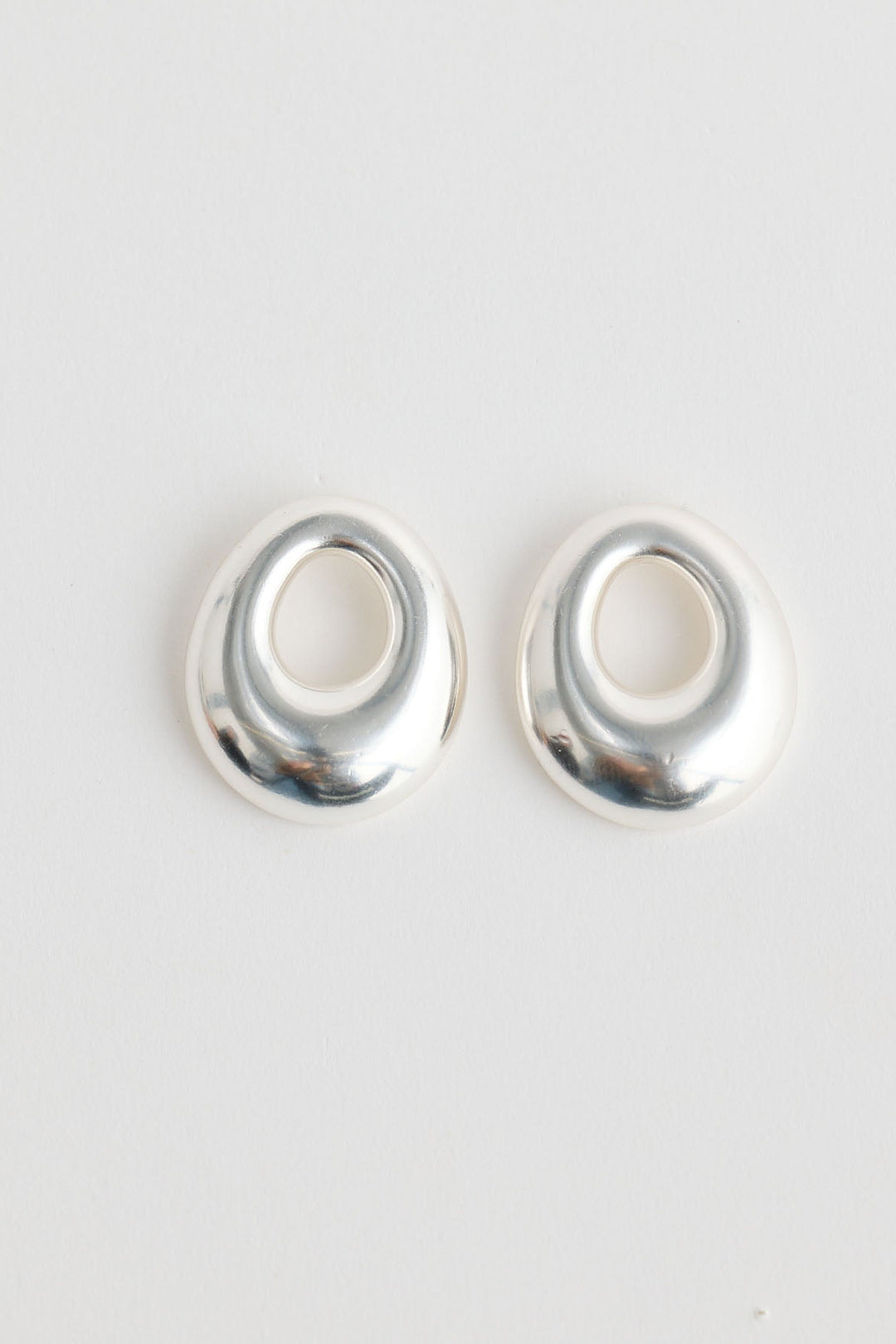Close-up of silver jordan earrings earrings on white background.