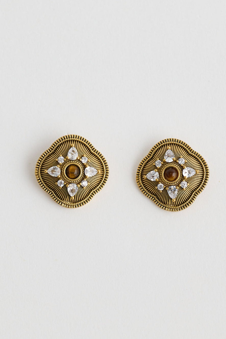 Close-up of gold quinn earrings earrings on white background.