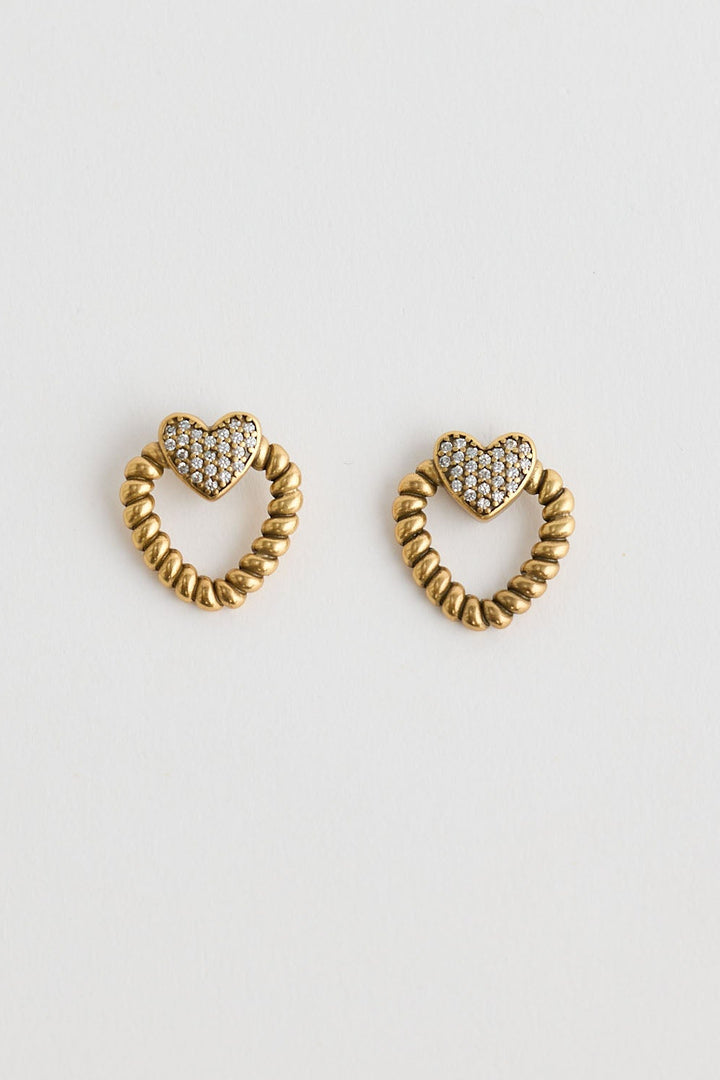 Close-up of gold charlie earrings earrings on white background.