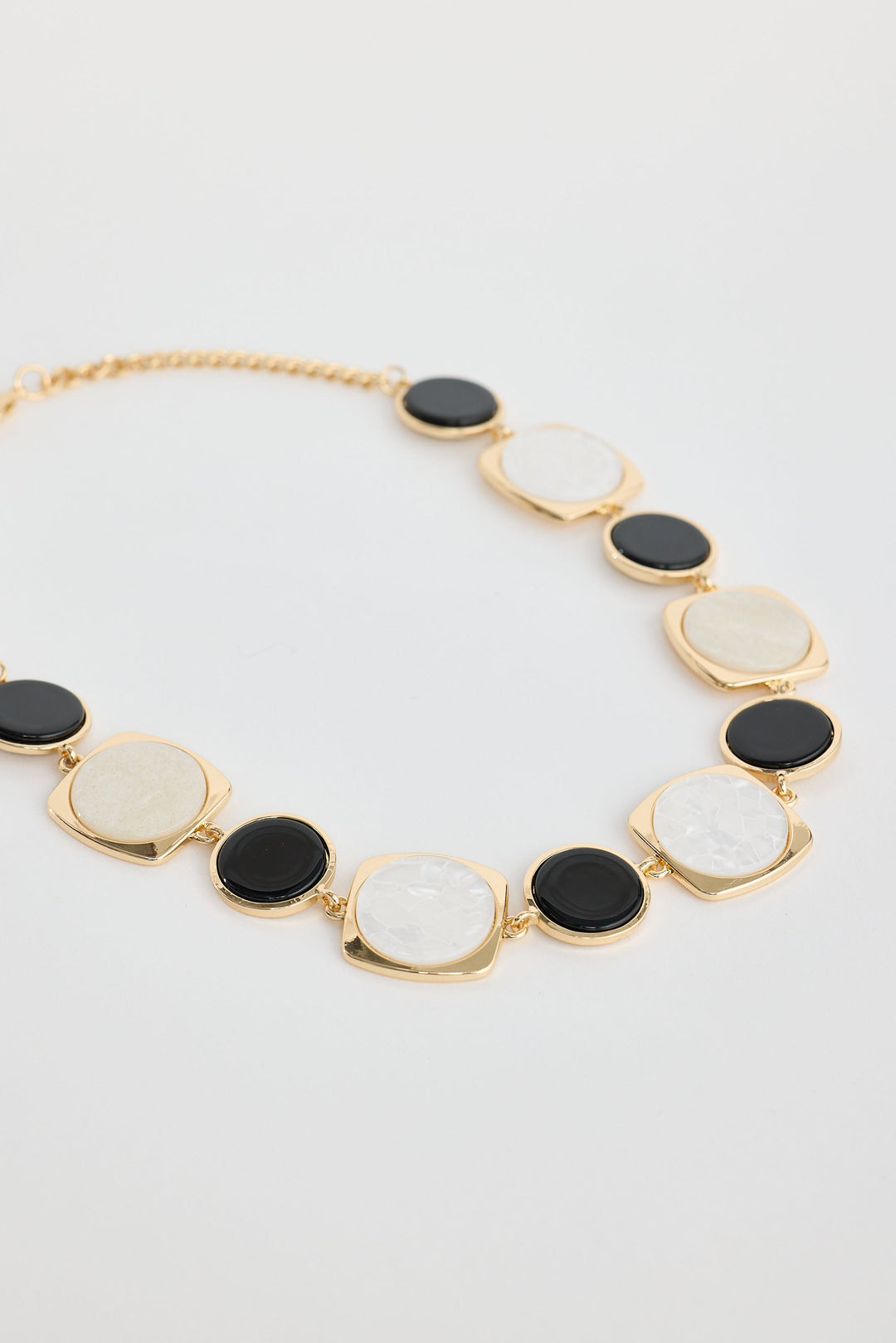 Close-up of black w white wendy necklace necklace on white background.