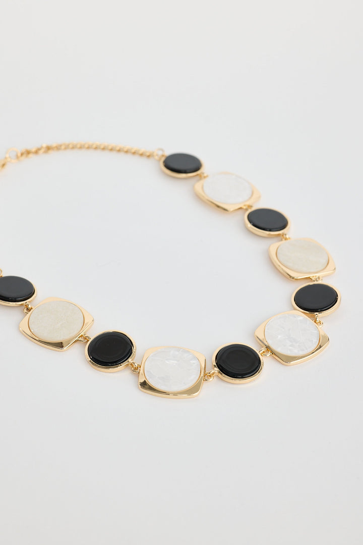 Close-up of black w white wendy necklace necklace on white background.