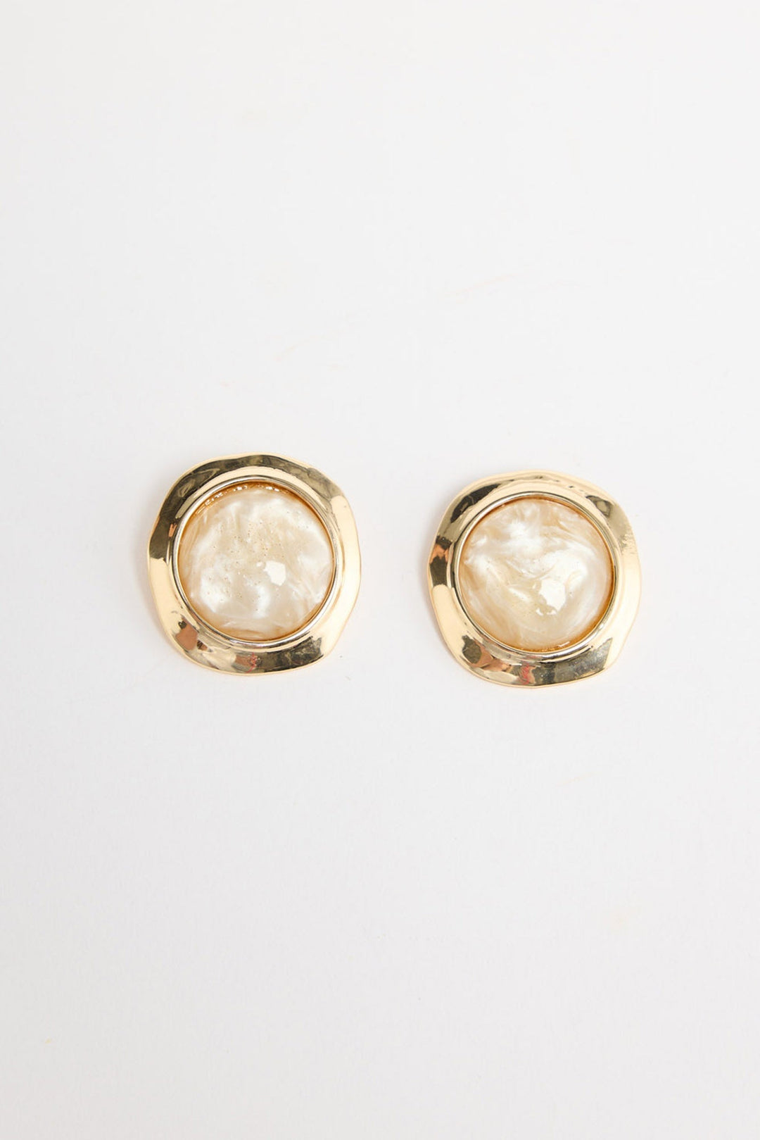 Pair of large square gold-tone stud earrings each set with a round cream mother-of-pearl resin stone in a hammered bezel, laid flat on a white background