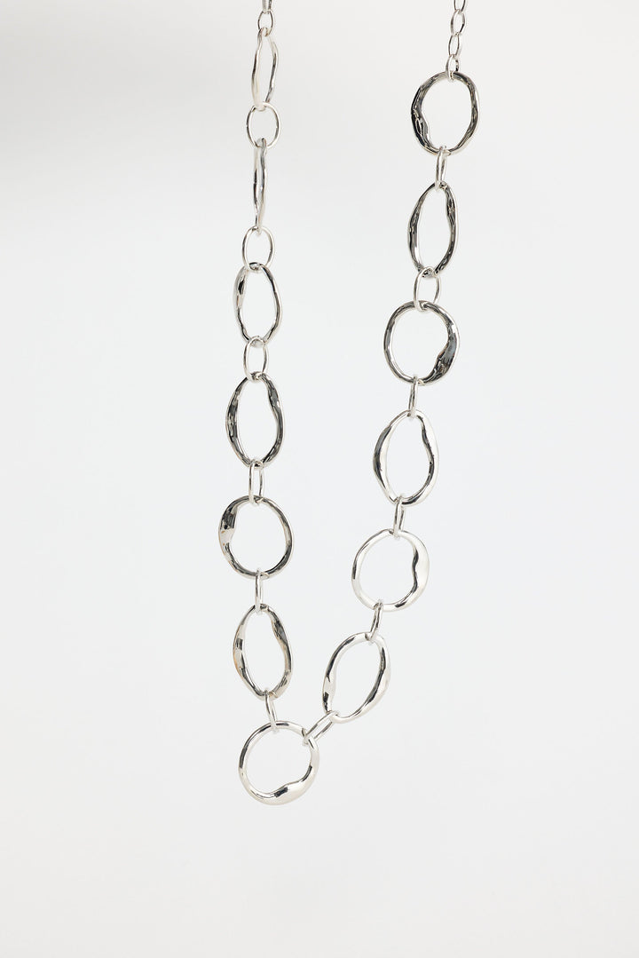 Close-up of silver hemsworth necklace necklace on white background.