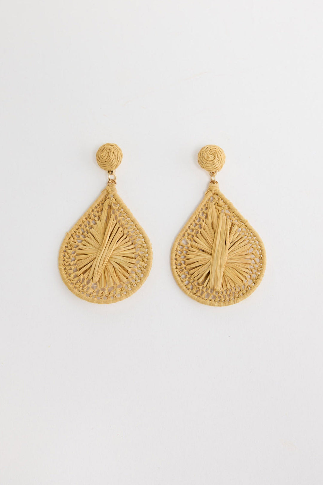 Pair of large teardrop-shaped natural raffia drop earrings with an open lattice weave edge and a sunburst raffia fringe centre, with a round coiled raffia stud, laid flat on a white background