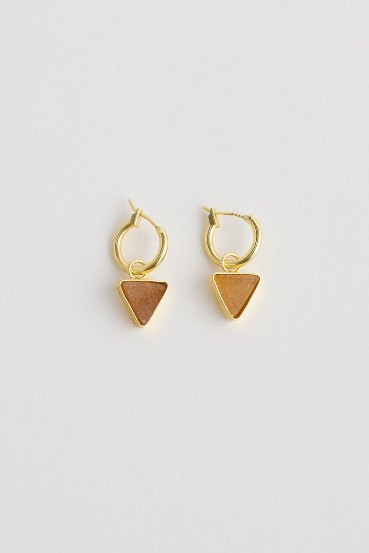 Close-up of cocoa parton earrings earrings on white background.