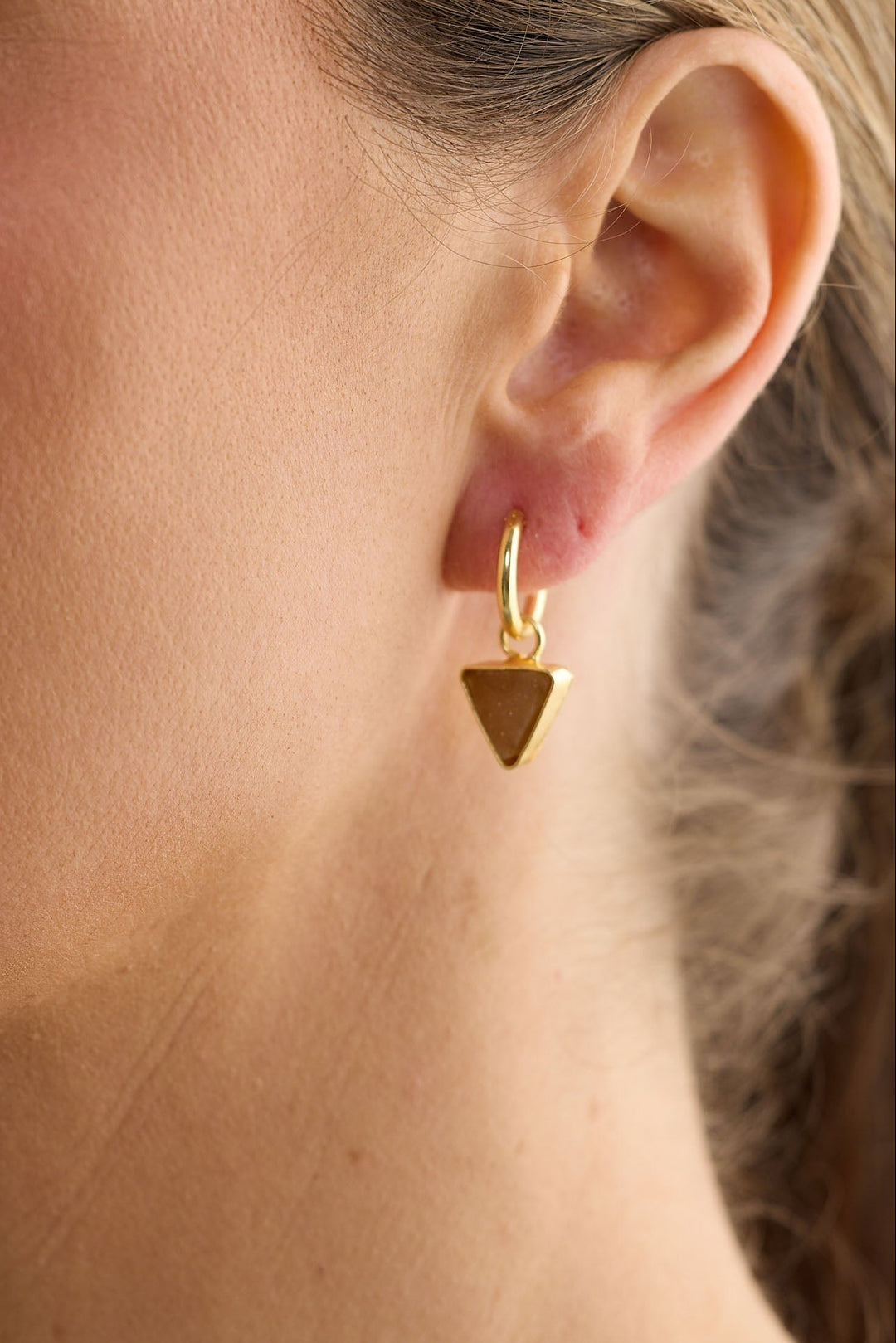 Close-up of cocoa parton earrings earrings on white background.