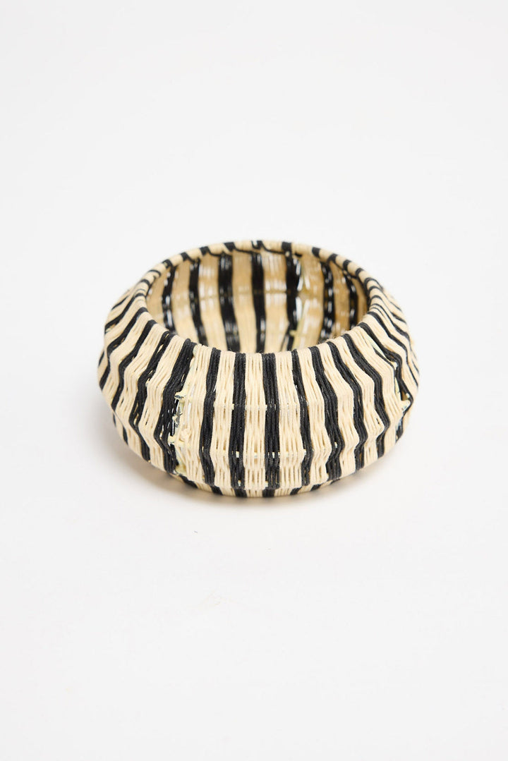 Top-down view of the Lancer Bangle in Stripe showing the woven cotton thread stripe pattern and rounded silhouette