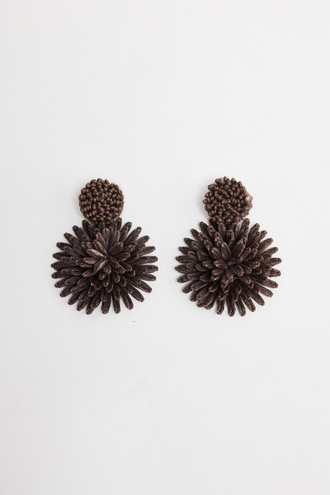 Pair of Polly statement earrings in Chocolate showing the woven raffia burst design and round textured stud