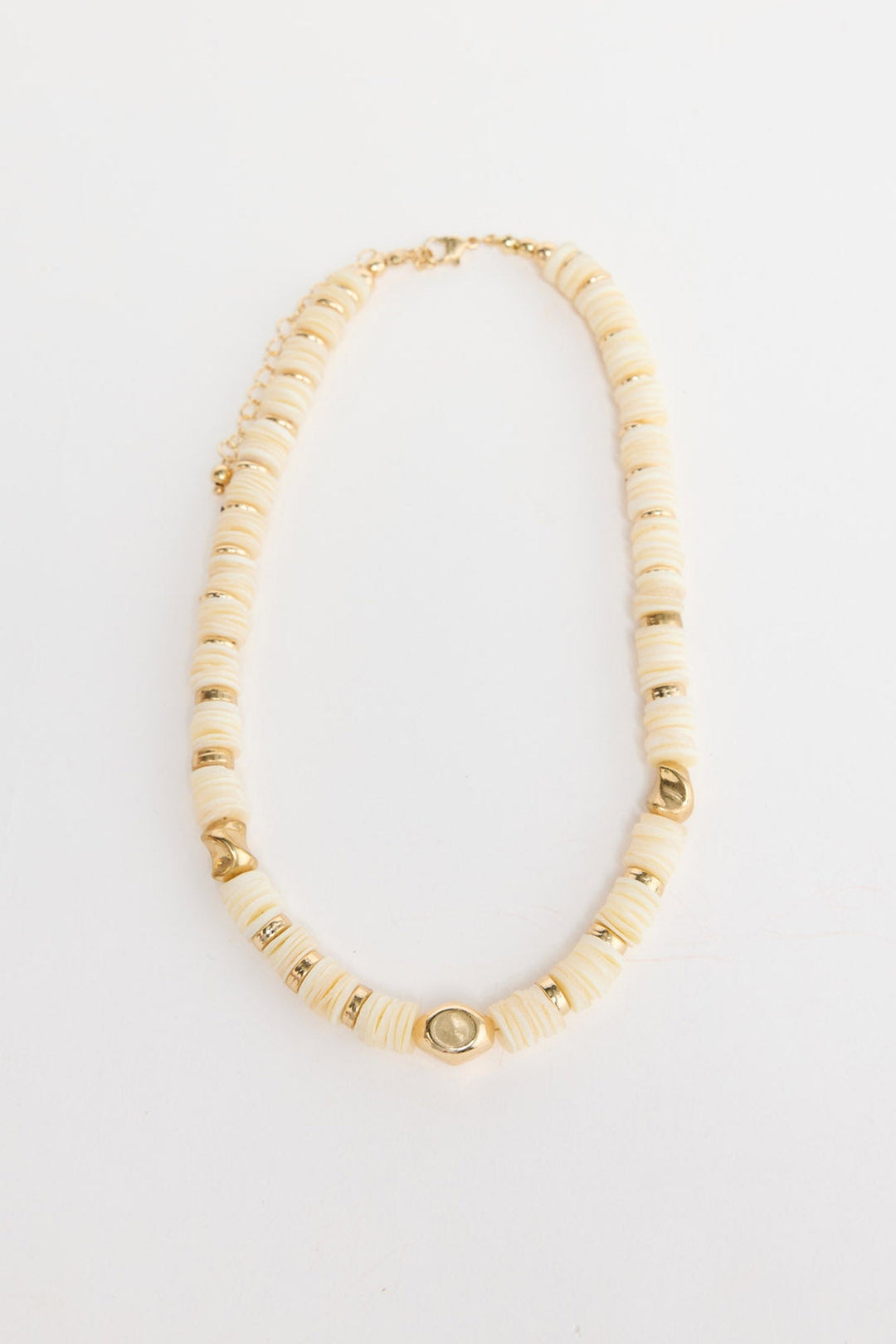 Cassian beaded necklace laid flat, showing cream disc beads interspersed with polished gold-tone accent beads