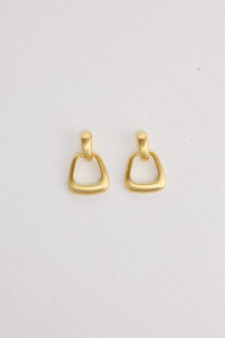 Swell Earrings in Gold – matte gold-tone geometric ring drop earrings shown flat on a white background.