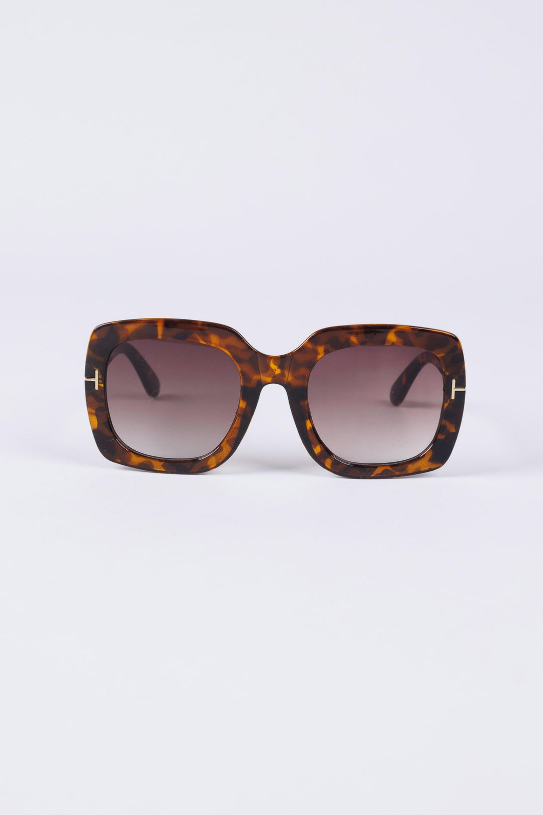Sunglasses with tortoiseshell frame and gradient lenses on a white background