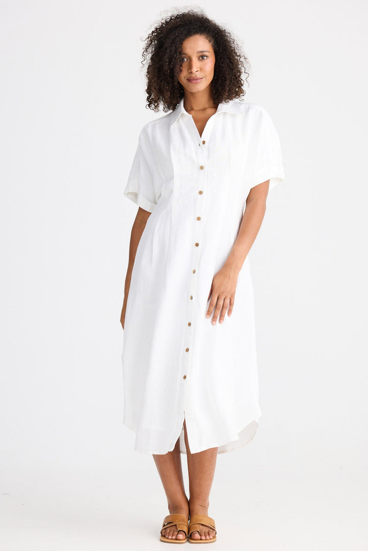 Woman wearing a white dress with buttons on a white background