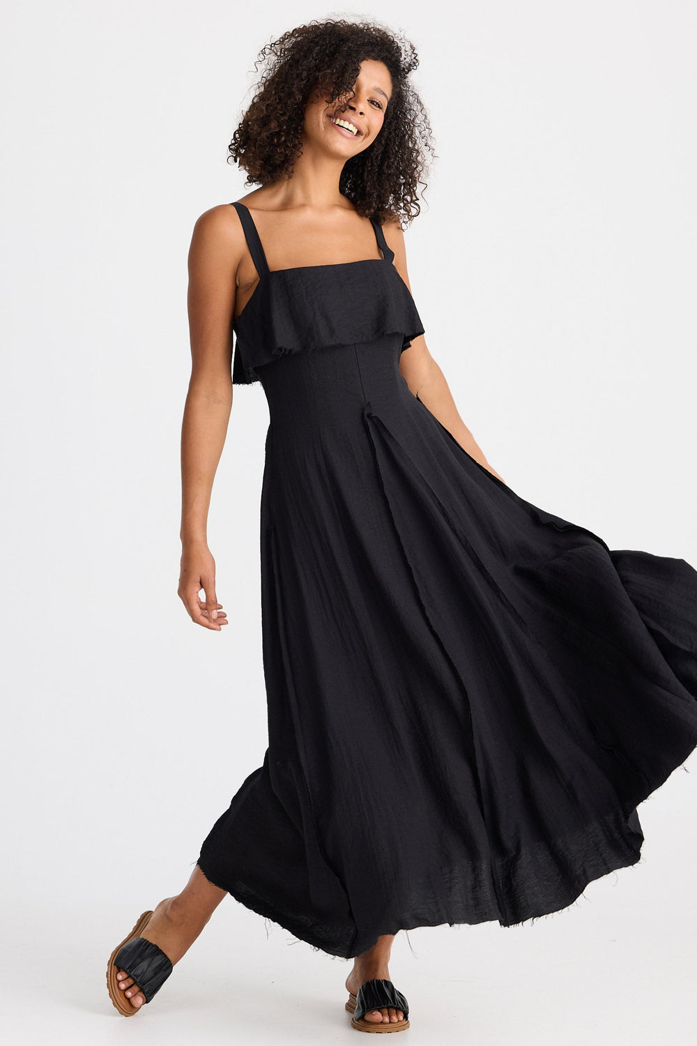 Woman wearing a black dress with ruffle on a white background