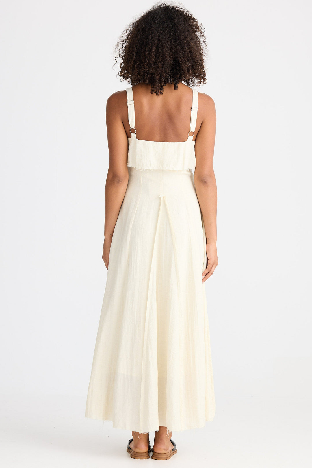 Woman wearing a cream dress on a white background