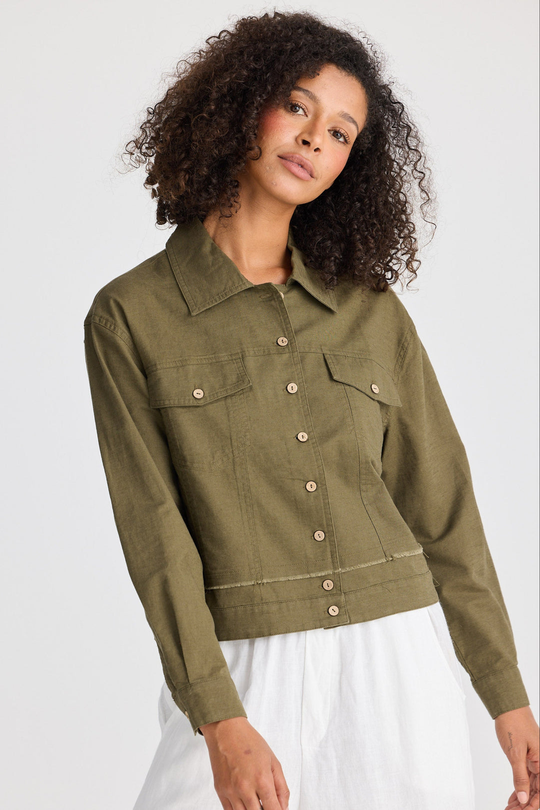 Woman wearing an olive green jacket on a white background