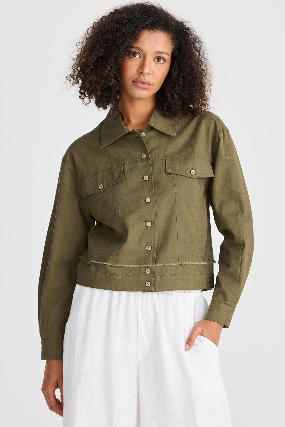 Woman wearing an olive green jacket on a white background