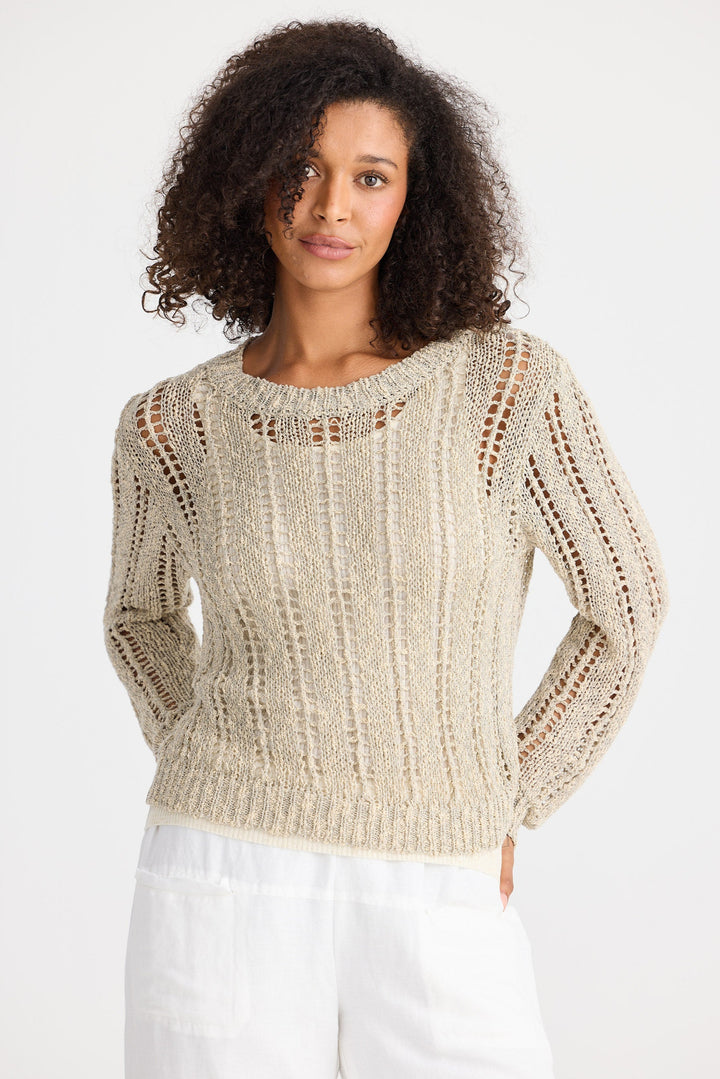 Woman wearing a beige knitted sweater on a white background