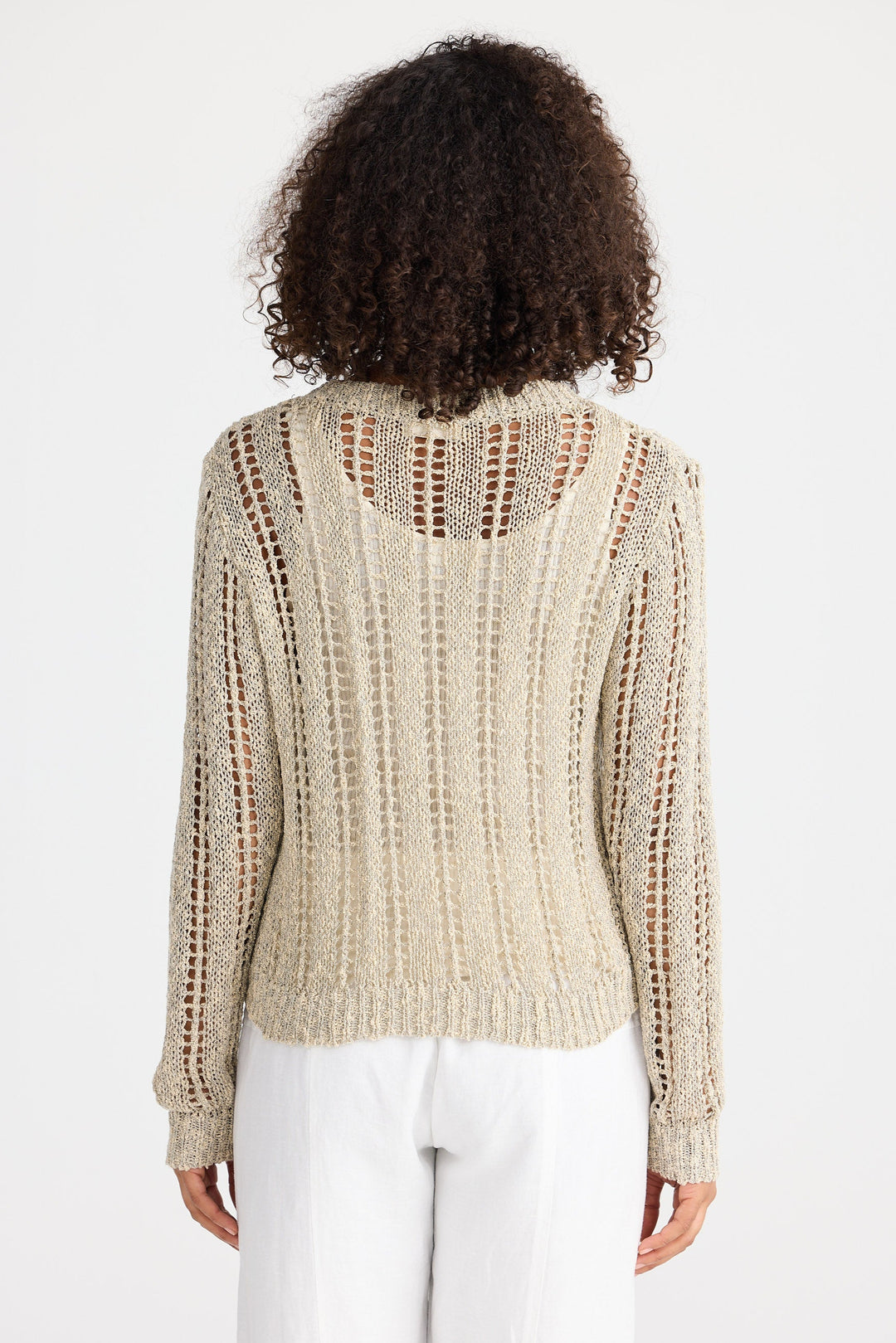 Person wearing a beige knitted sweater on a white background