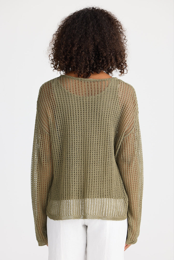 Person wearing a green knit sweater on a white background