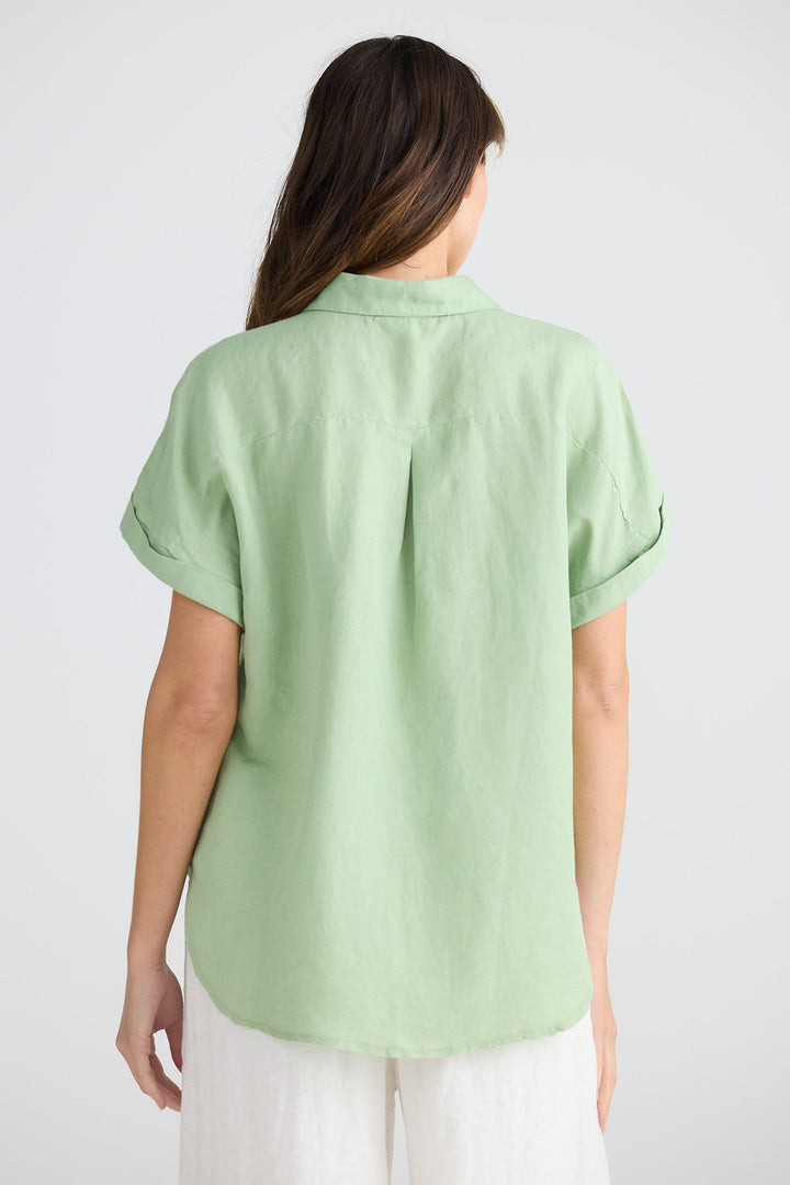 Person wearing a light green shirt on a white background