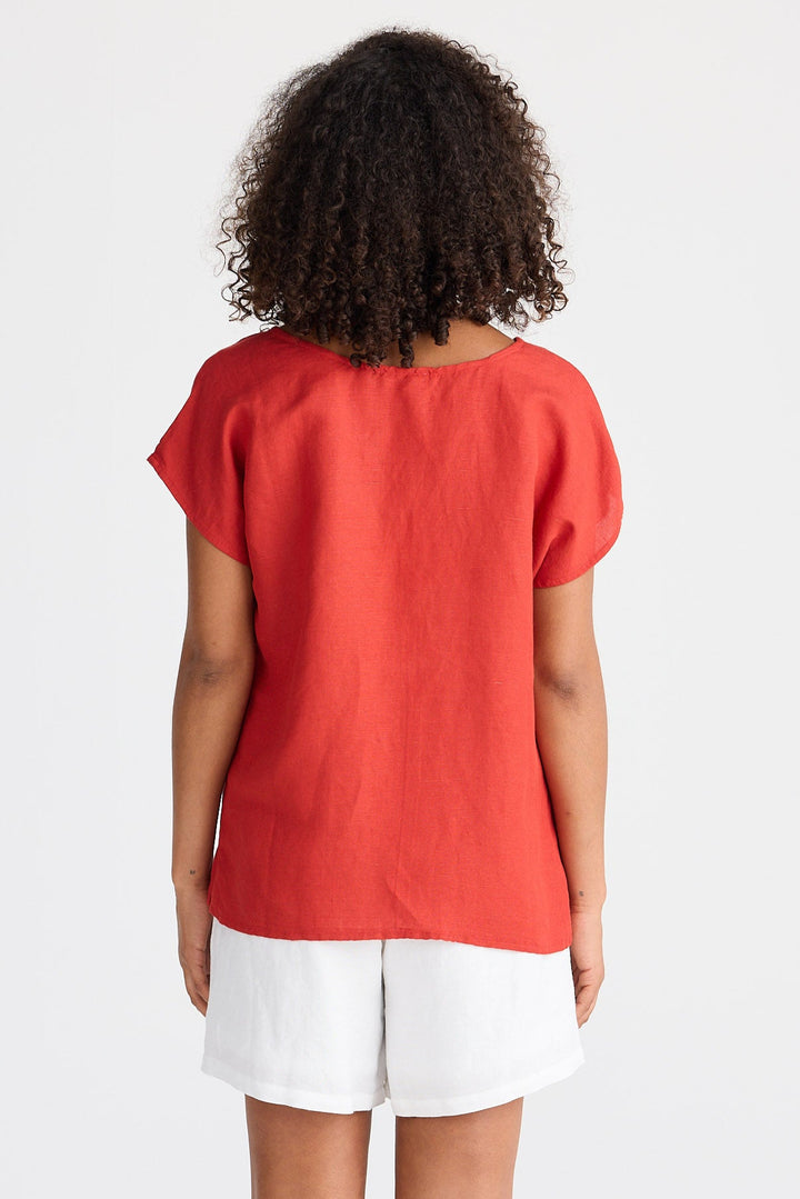 Person wearing a red top and white shorts on a white background