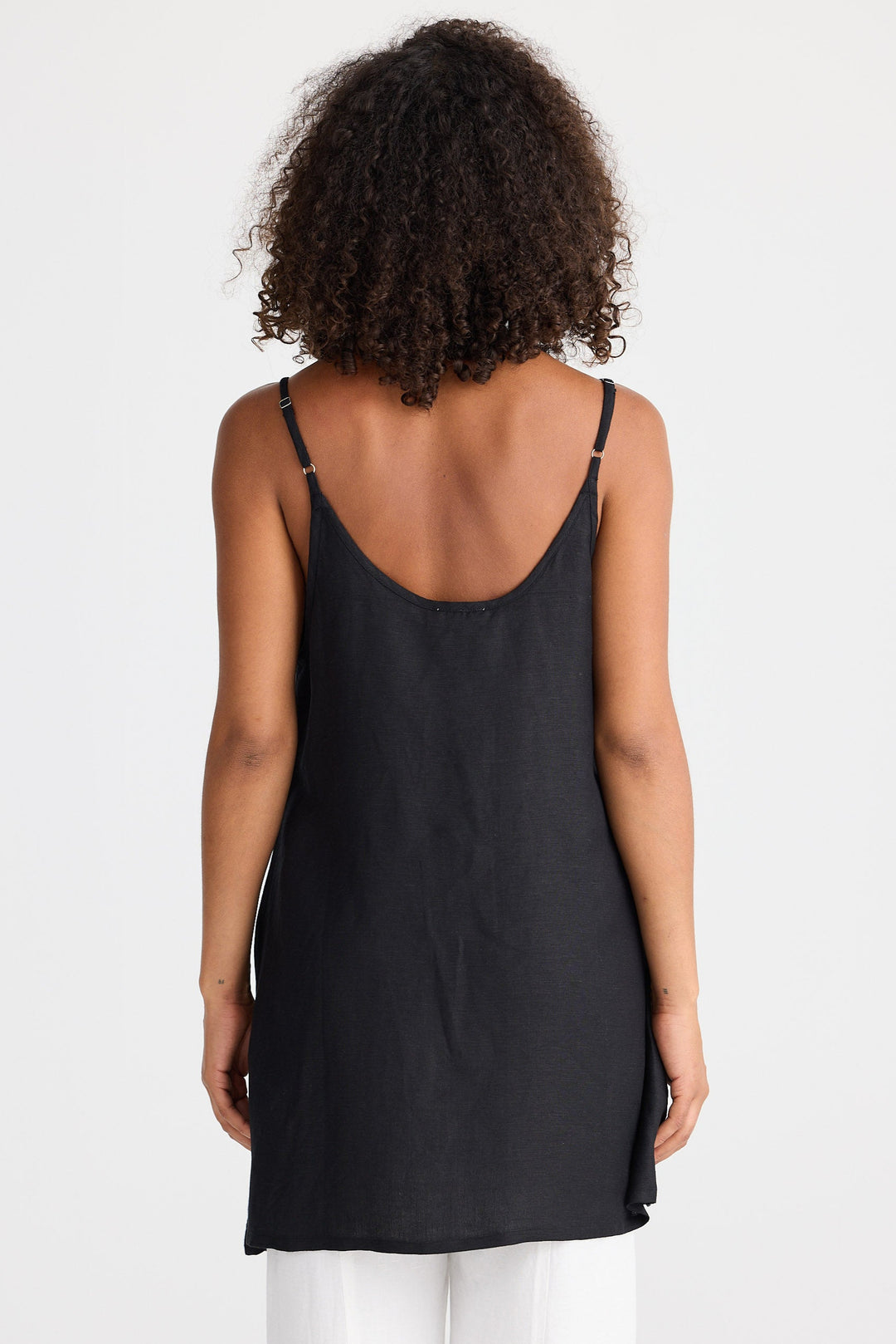 Person wearing a black sleeveless top on a white background