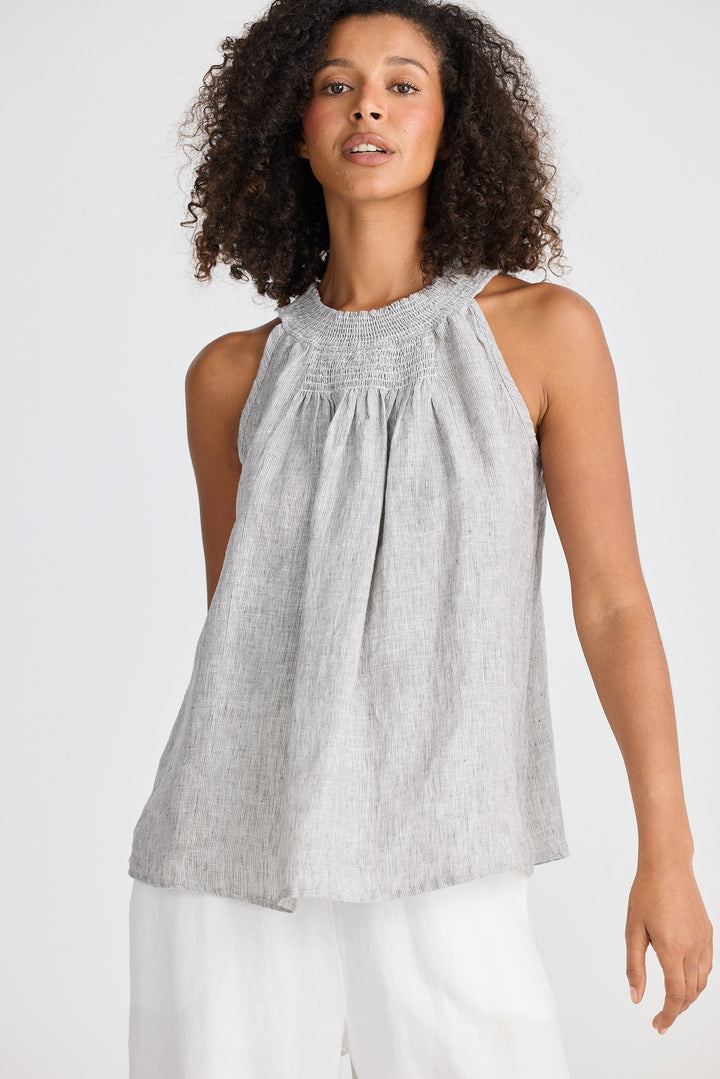 Woman wearing a gray sleeveless top with a white background