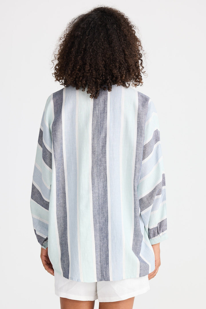 Person wearing a striped shirt and white shorts on a plain background