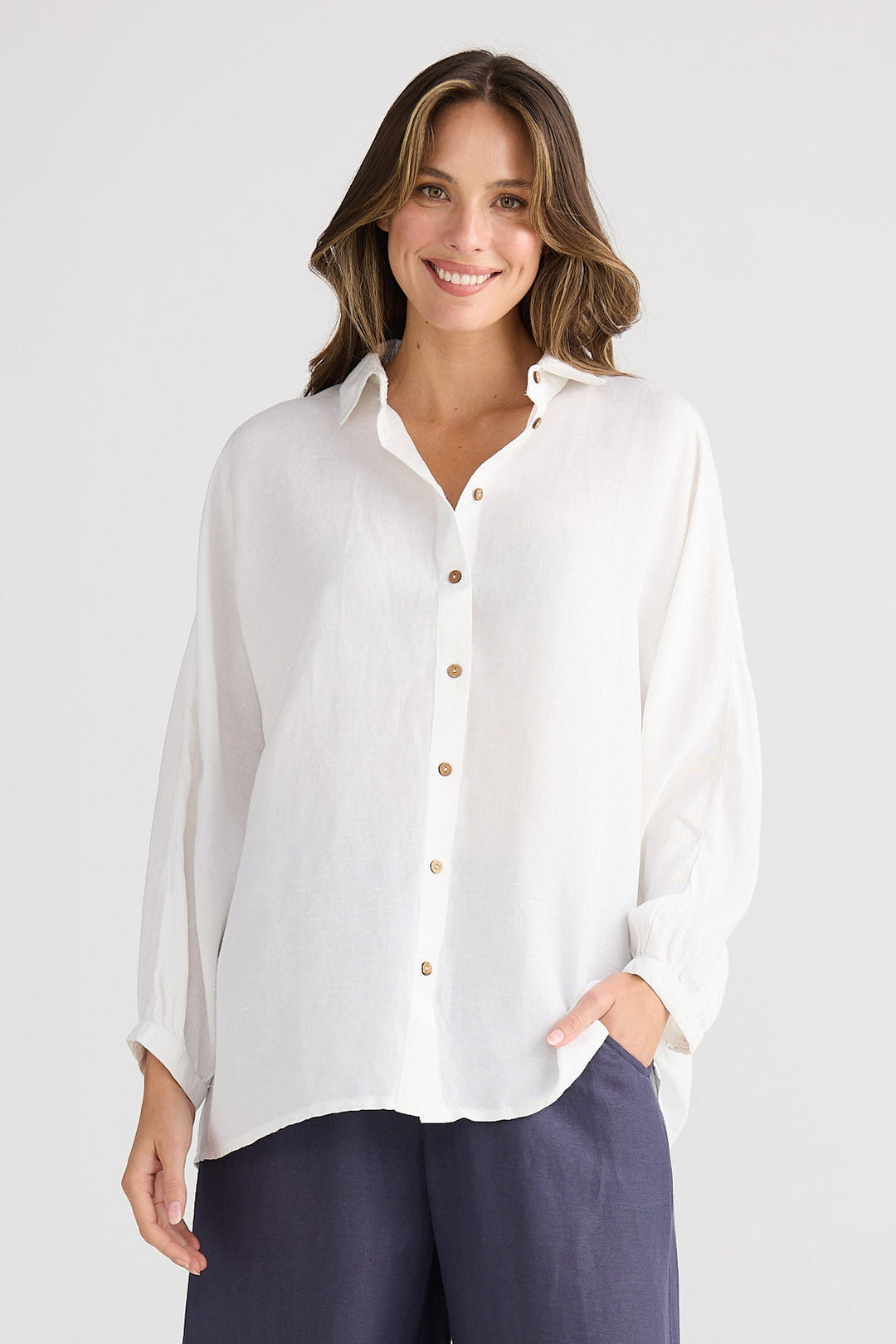 Woman wearing a white shirt and dark blue pants on a white background