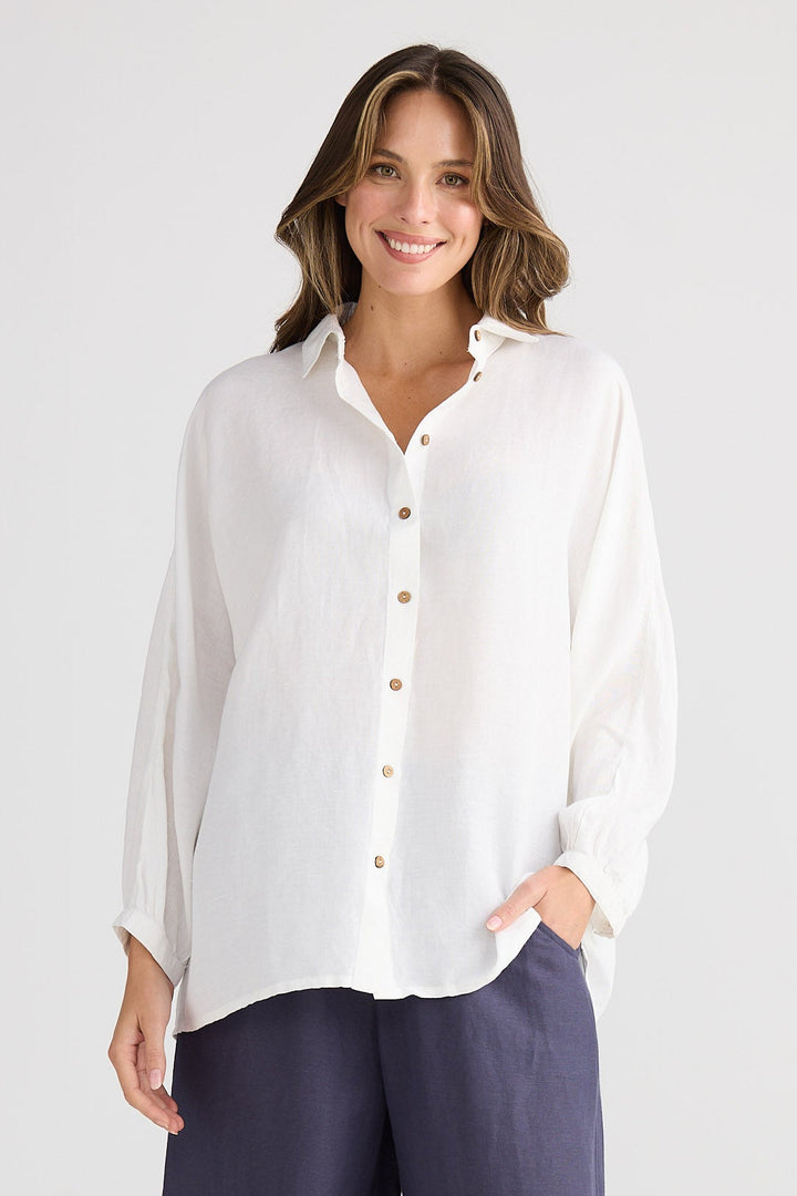 Woman wearing a white shirt and dark blue pants on a white background