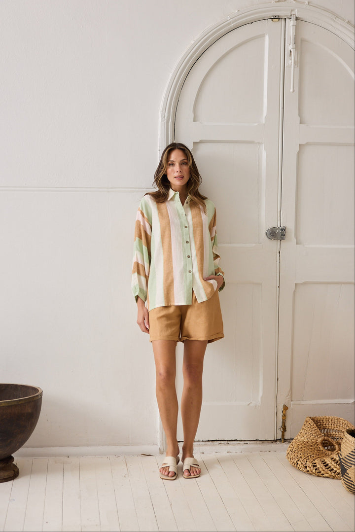 Woman standing in a room with a white door and wooden floor.