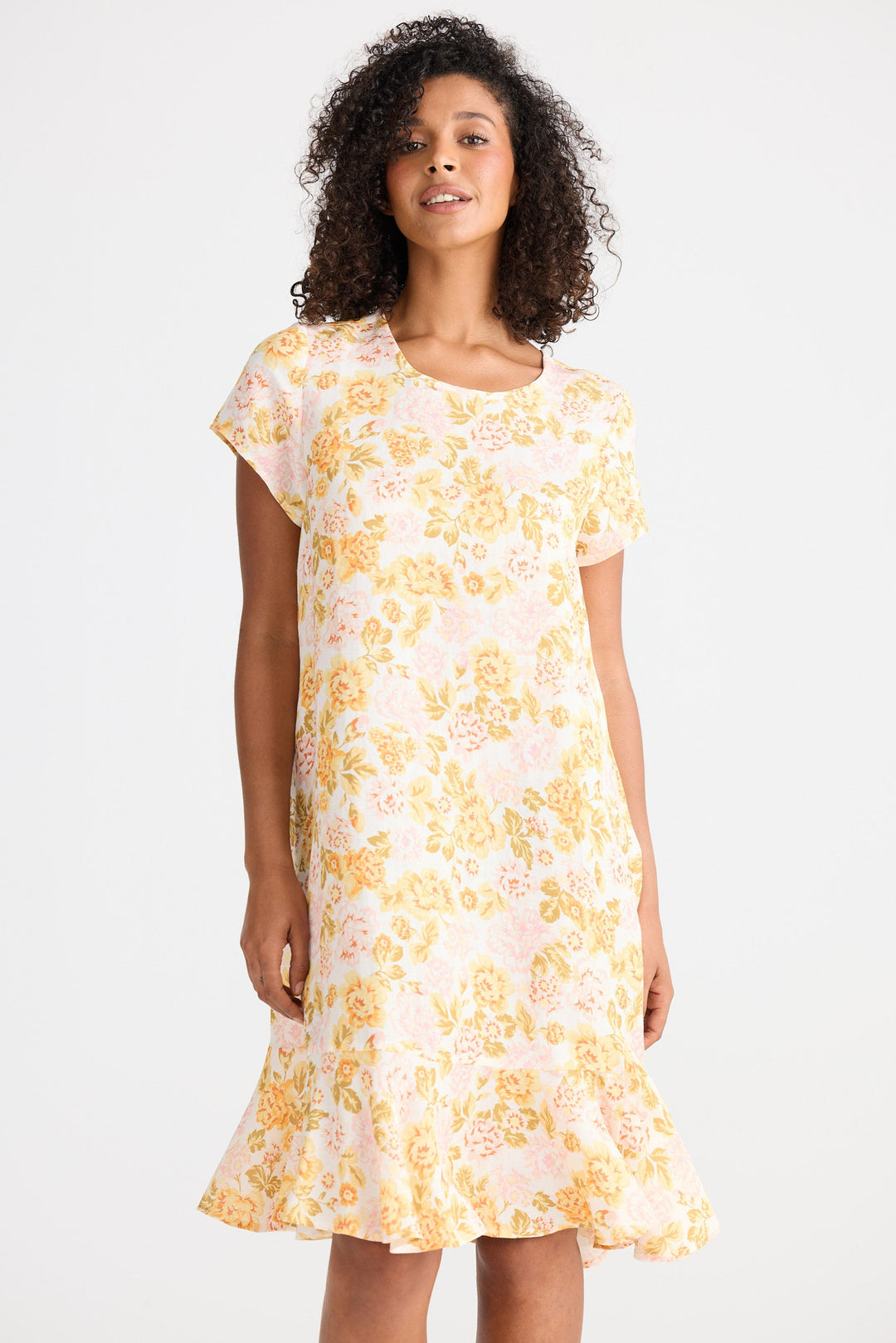Woman wearing a yellow floral dress on a white background