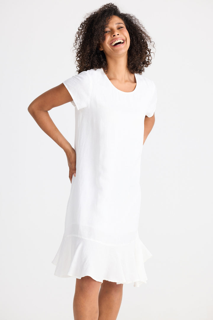 Woman wearing a white dress against a plain background