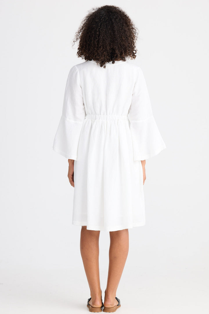 Person wearing a white dress with a plain background