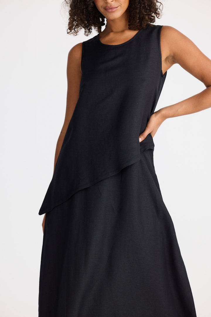 Woman wearing a black sleeveless dress against a white background