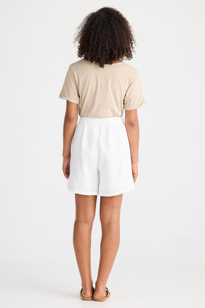 Person wearing a beige top and white shorts on a white background