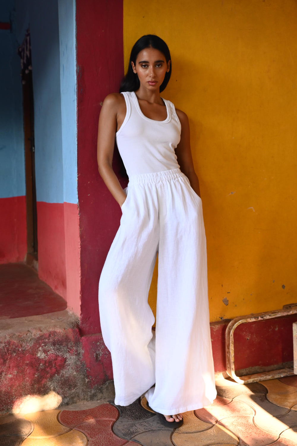Woman in a white top and pants standing on a colourful floor