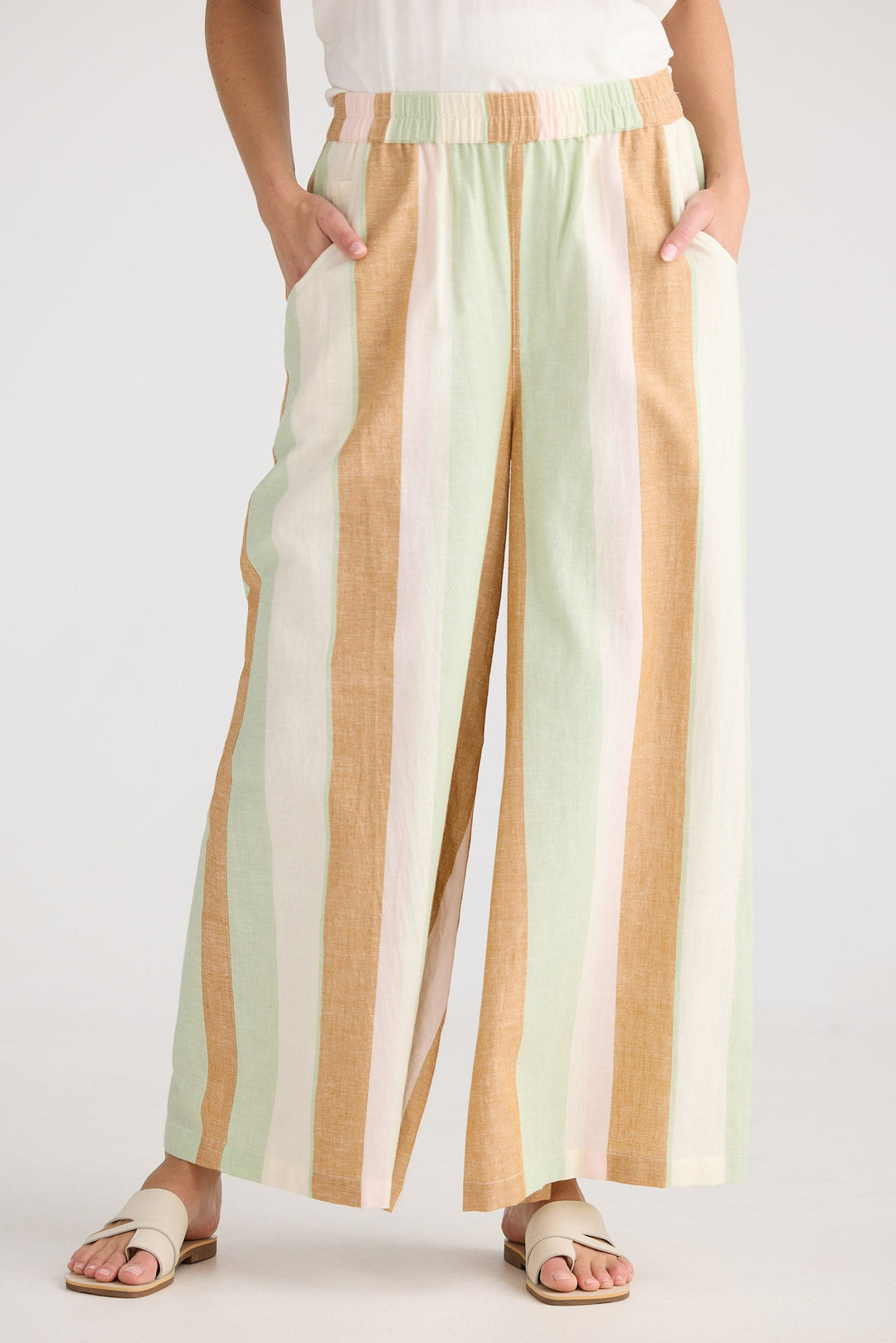 Person wearing pastel striped wide-leg pants on a white background