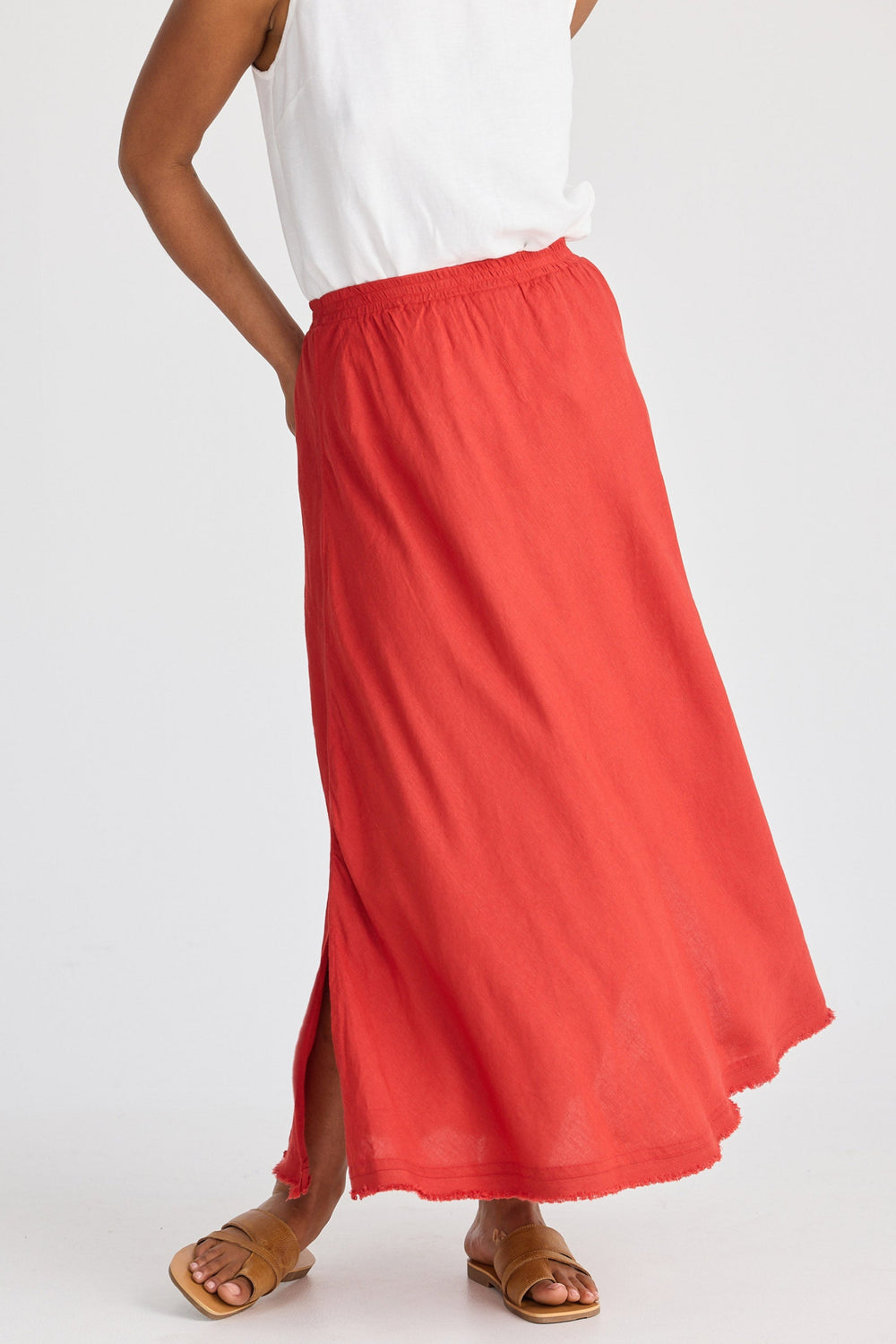 Person wearing a red skirt and white top on a white background
