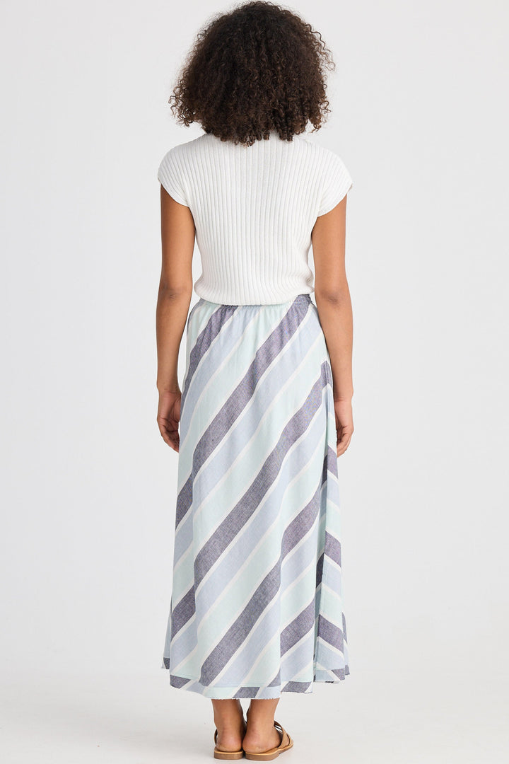 Person wearing a white top and striped skirt on a plain background
