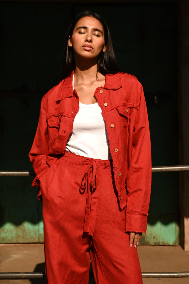 Person wearing a red jacket standing against a dark background