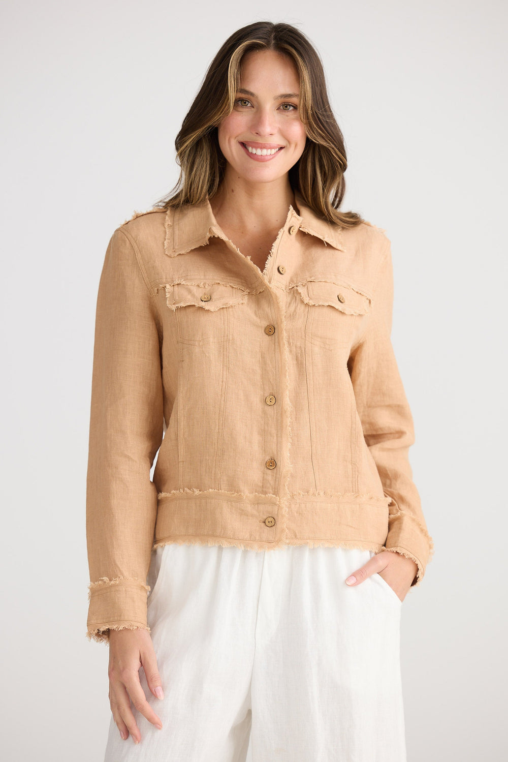 Woman wearing a beige denim jacket on a white background