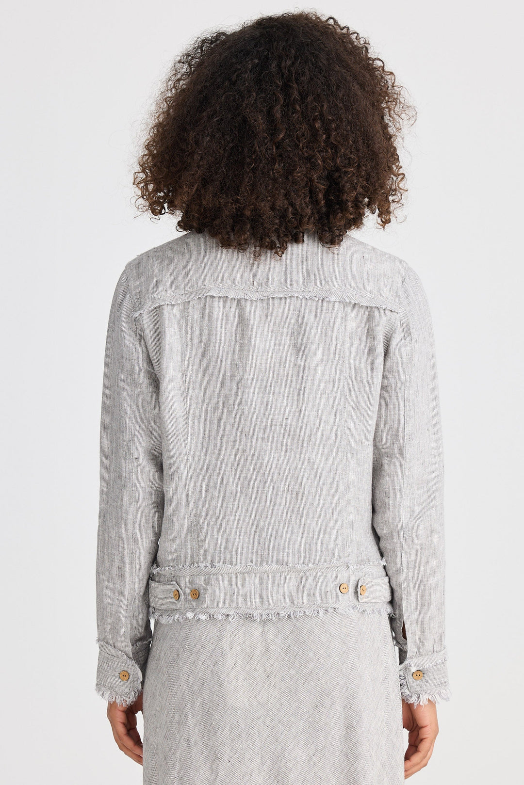 Person wearing a light gray jacket and dress on a white background