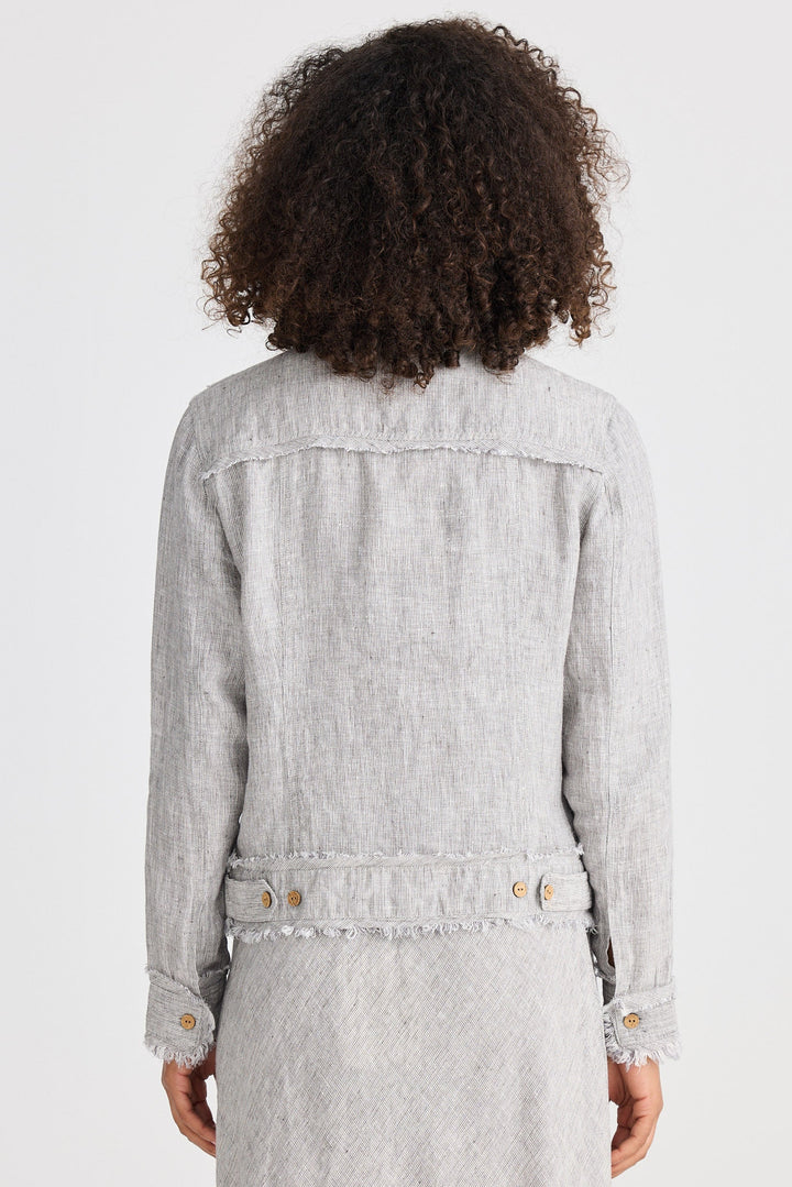 Person wearing a light gray jacket and dress on a white background