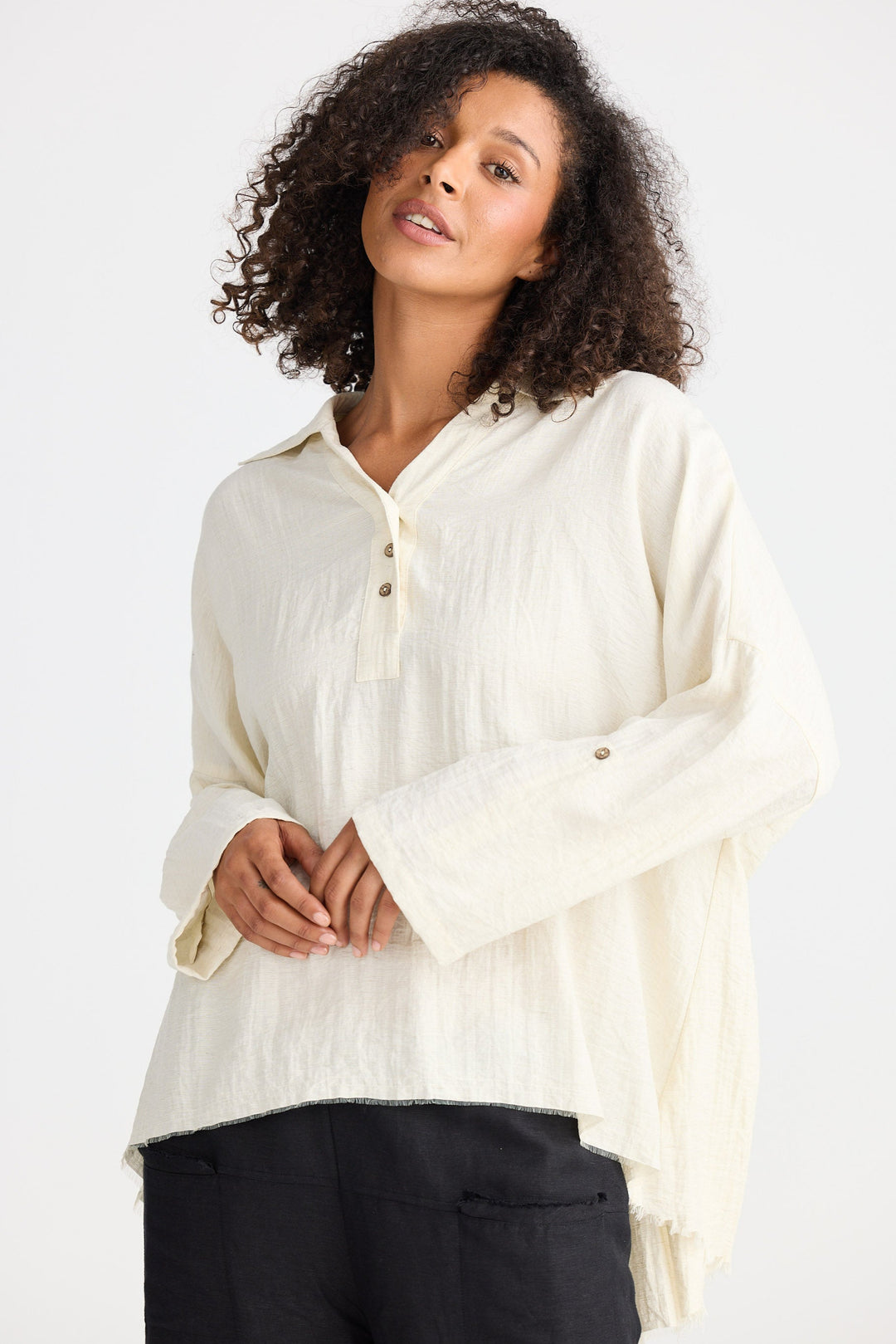 Woman wearing a light-colored blouse against a white background