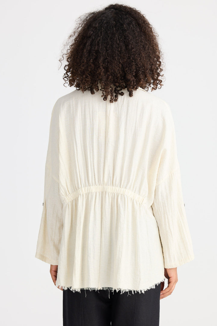 Person wearing a light coloured shirt on a plain background