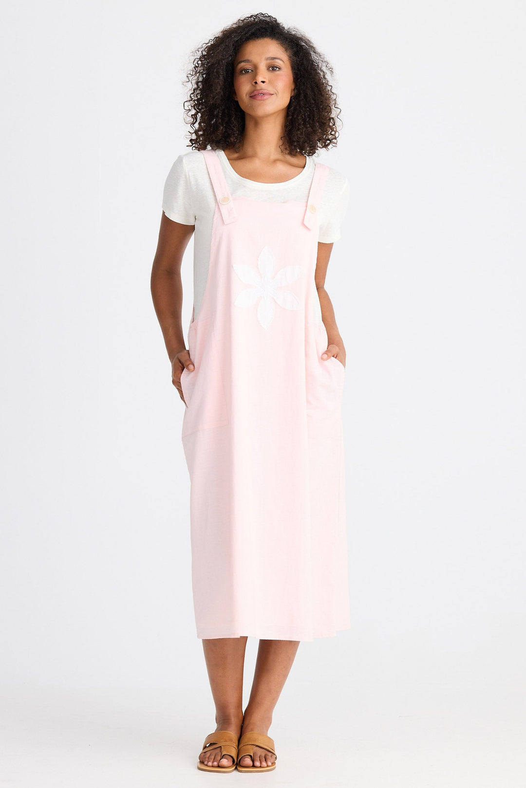 Woman wearing a light pink dress with a white top on a white background