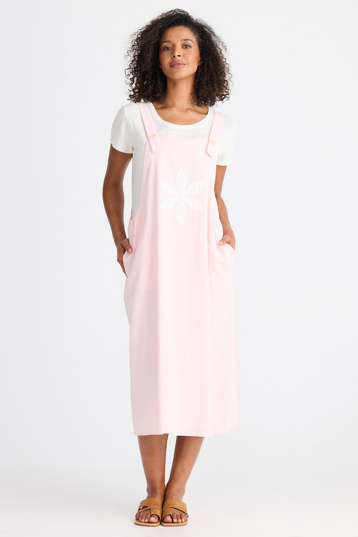 Woman wearing a light pink dress with a white top on a white background