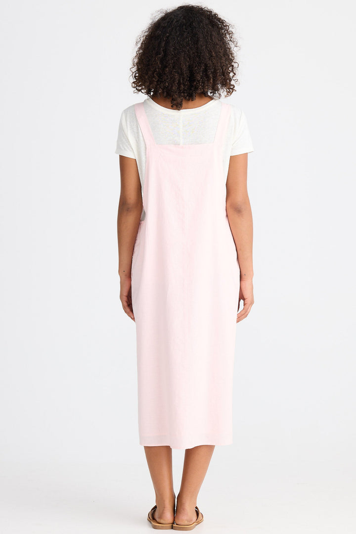 Person wearing a light pink dress with a white top on a white background